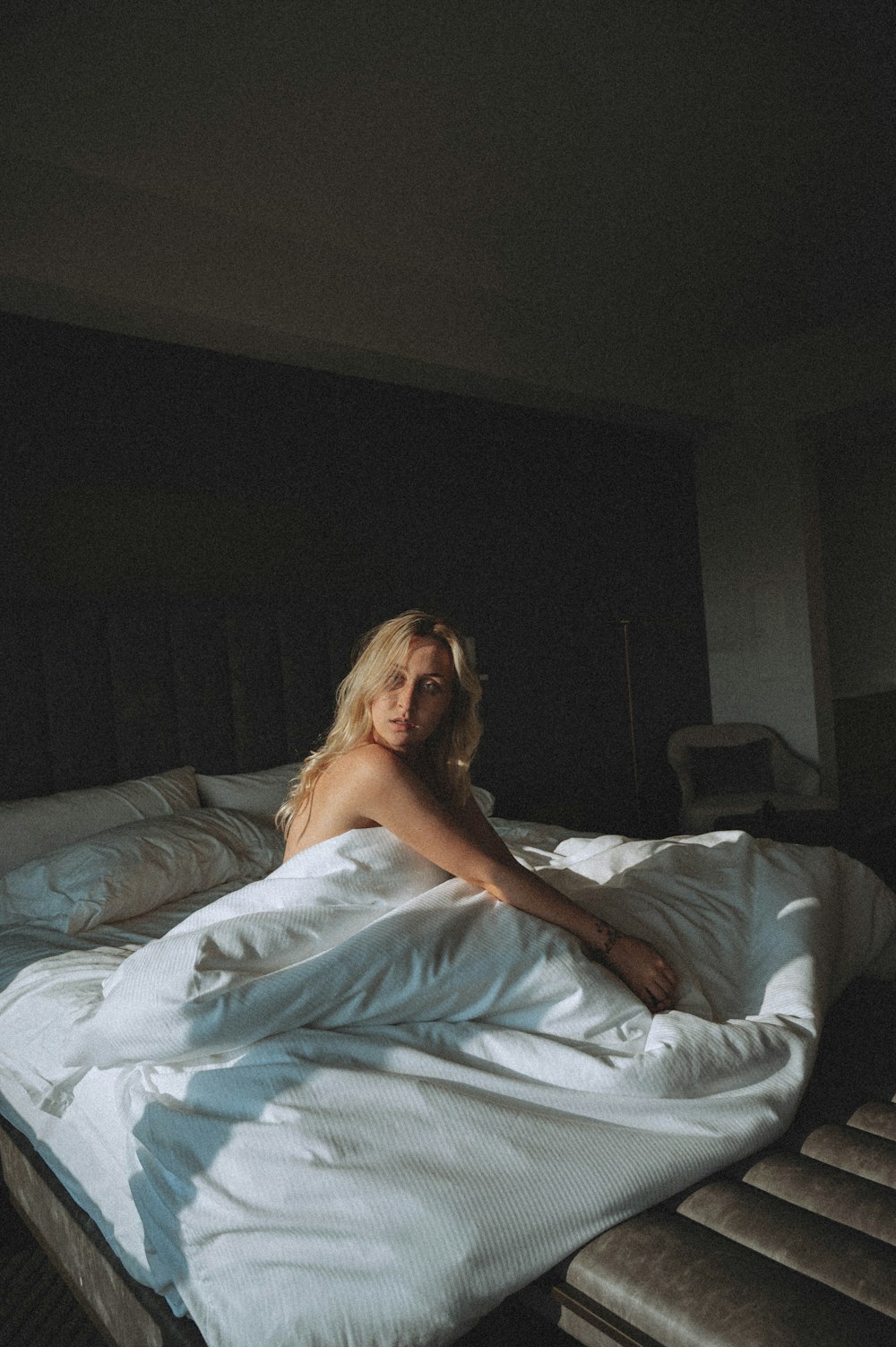 woman in white tube dress lying on bed