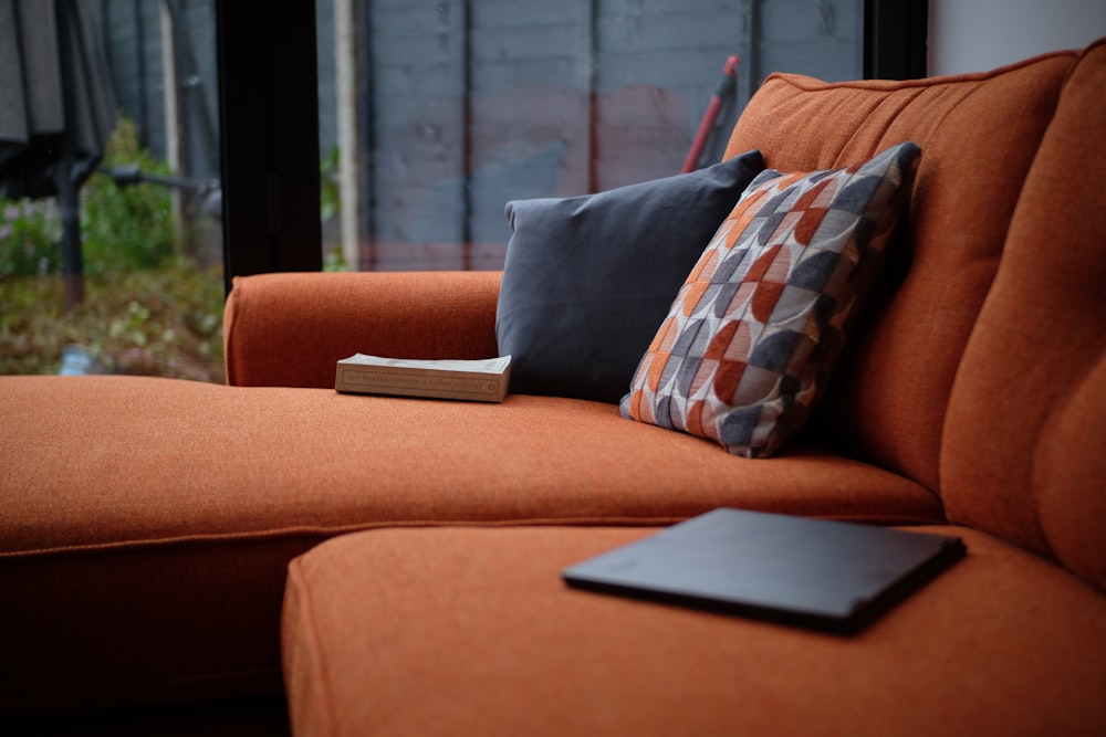 black laptop computer on brown couch