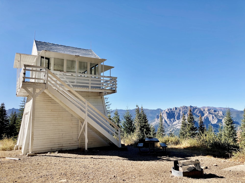 white and gray house near green trees and mountain during daytime