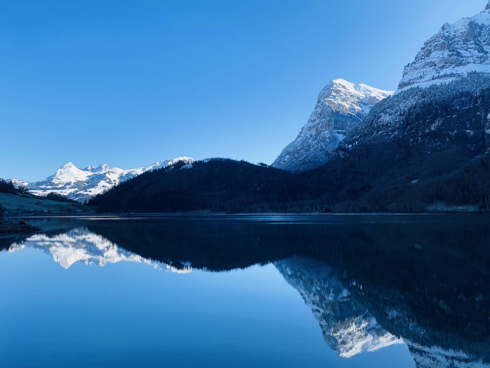 lake near snow covered mountains during daytime