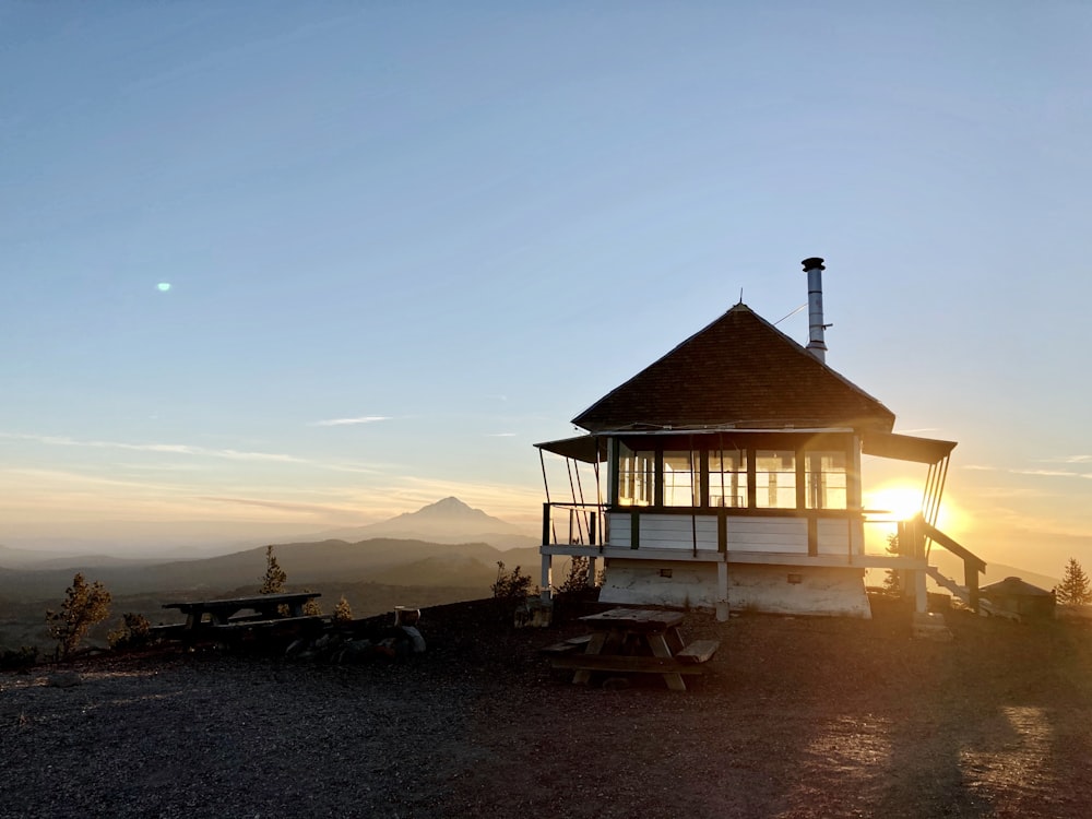 brown wooden house on beach during sunset