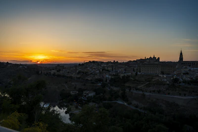 A serene sunset over a historic city skyline with ancient architecture.