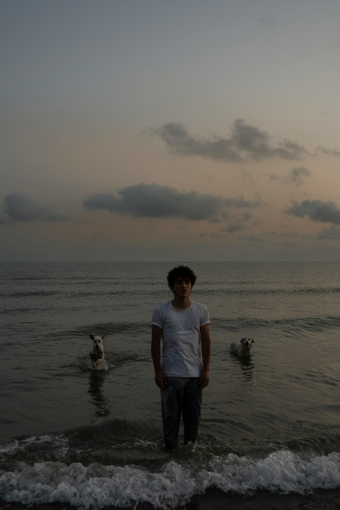 man in white t-shirt and black shorts standing on sea shore