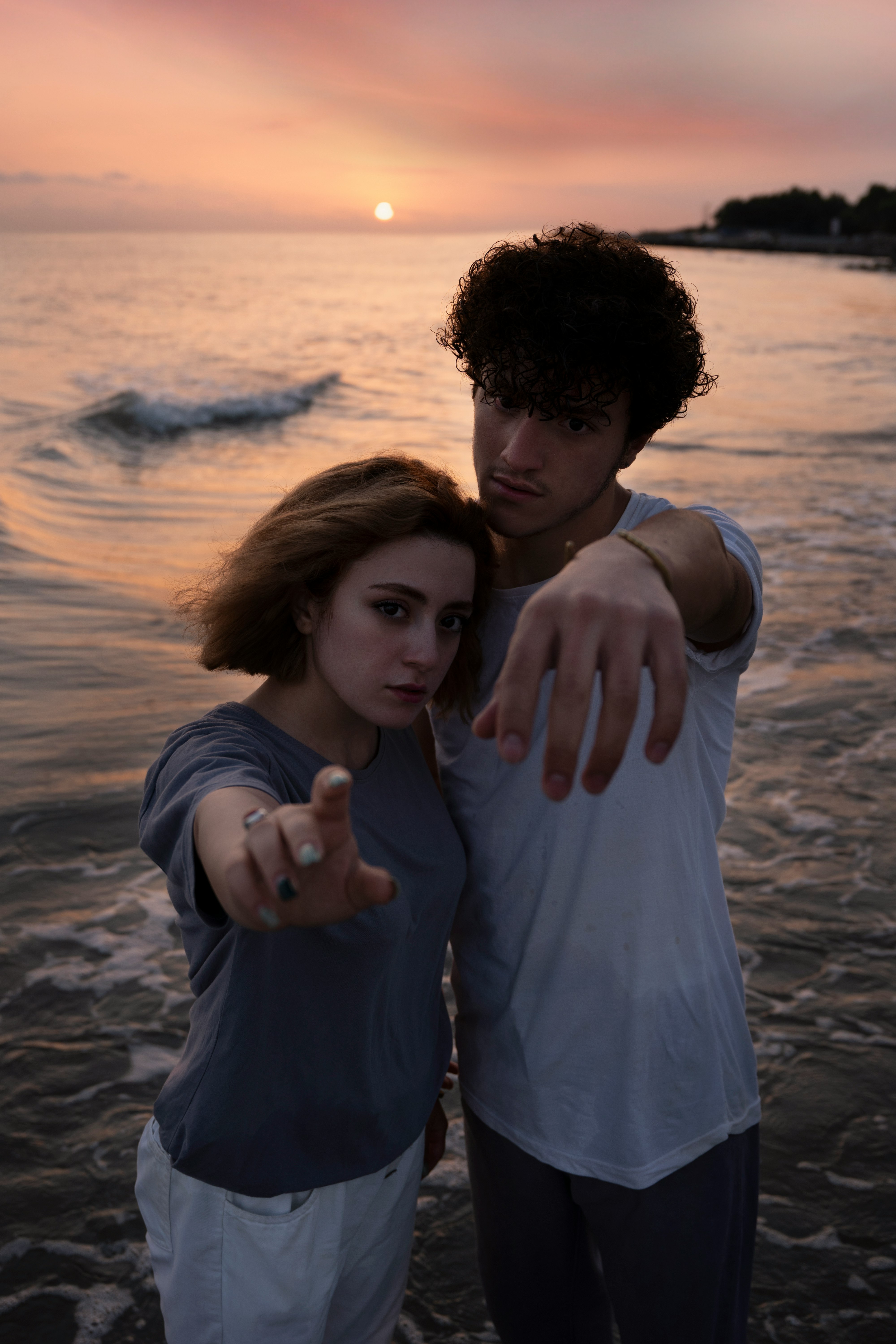 man and woman standing on beach during daytime