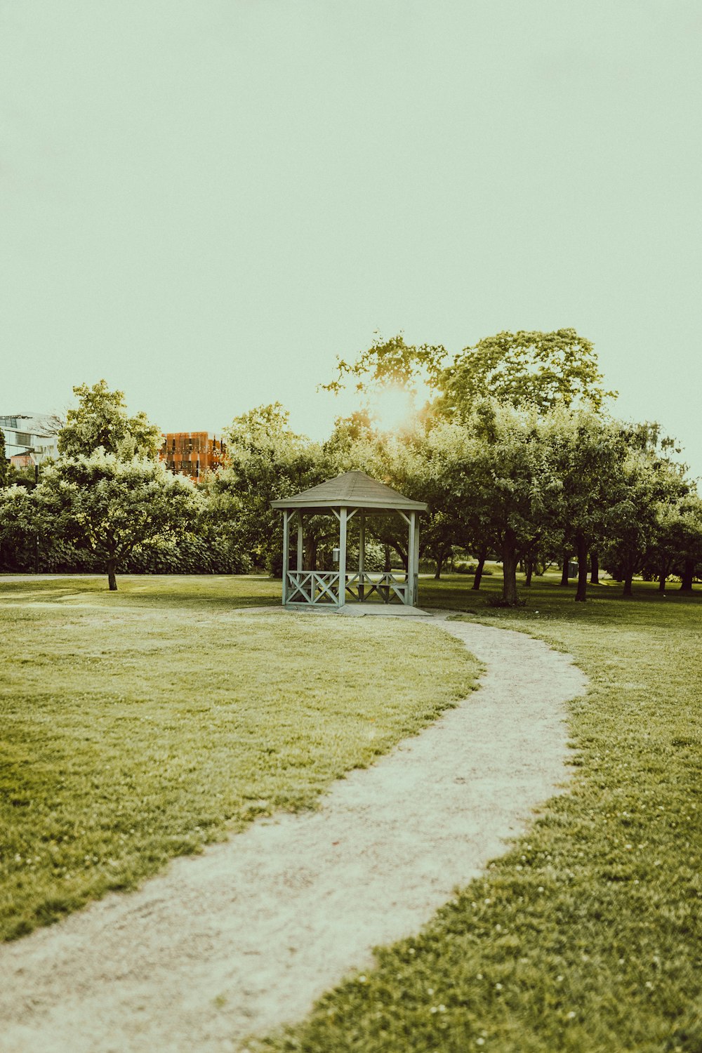 green grass field with trees and brown wooden house