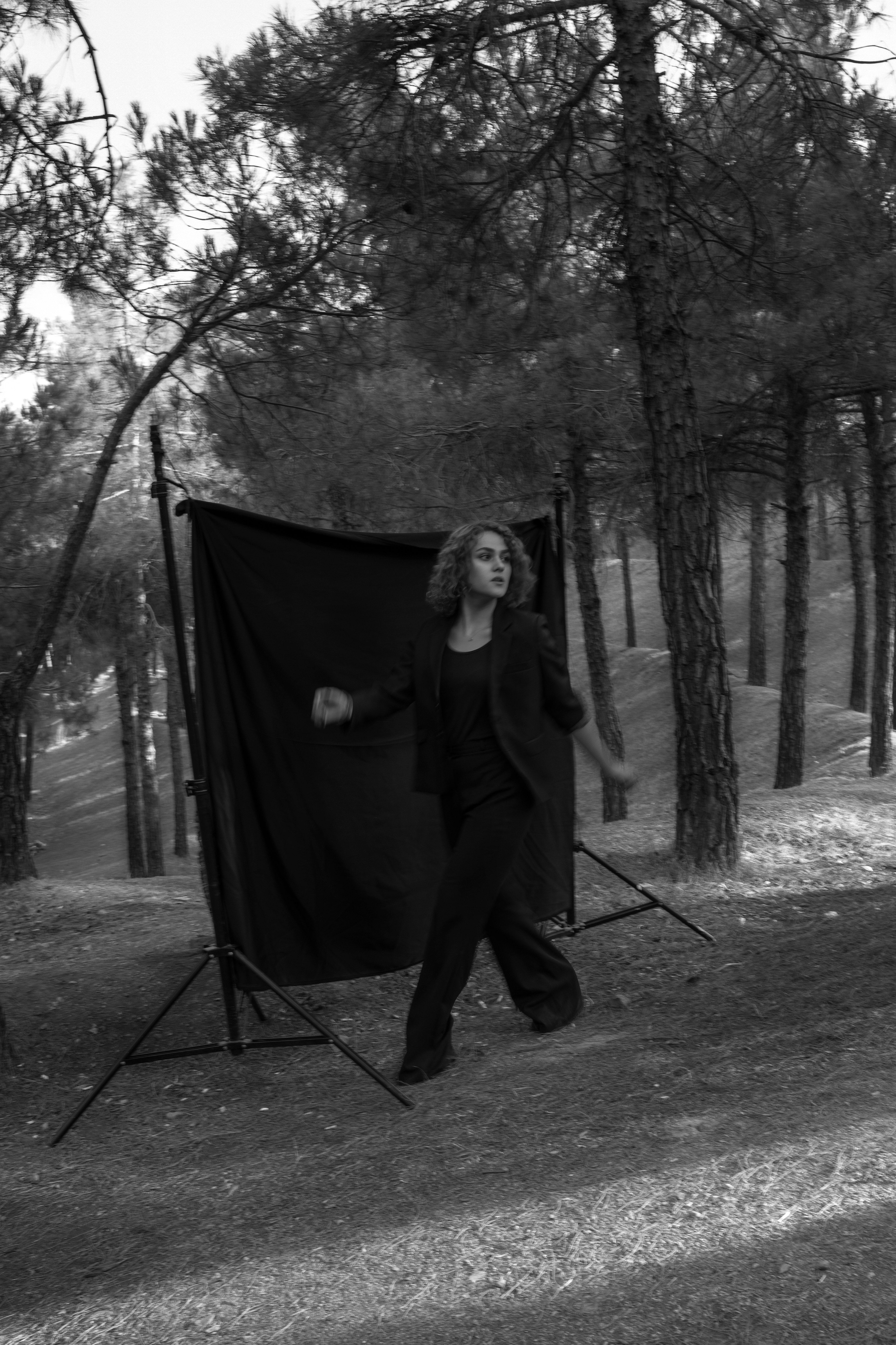 woman in black coat standing on forest