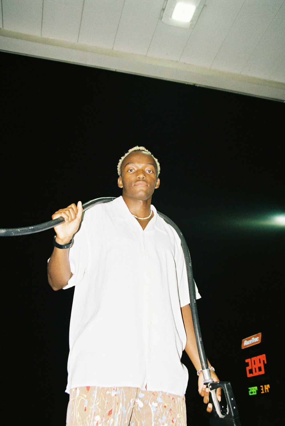 man in white polo shirt holding black and white stick