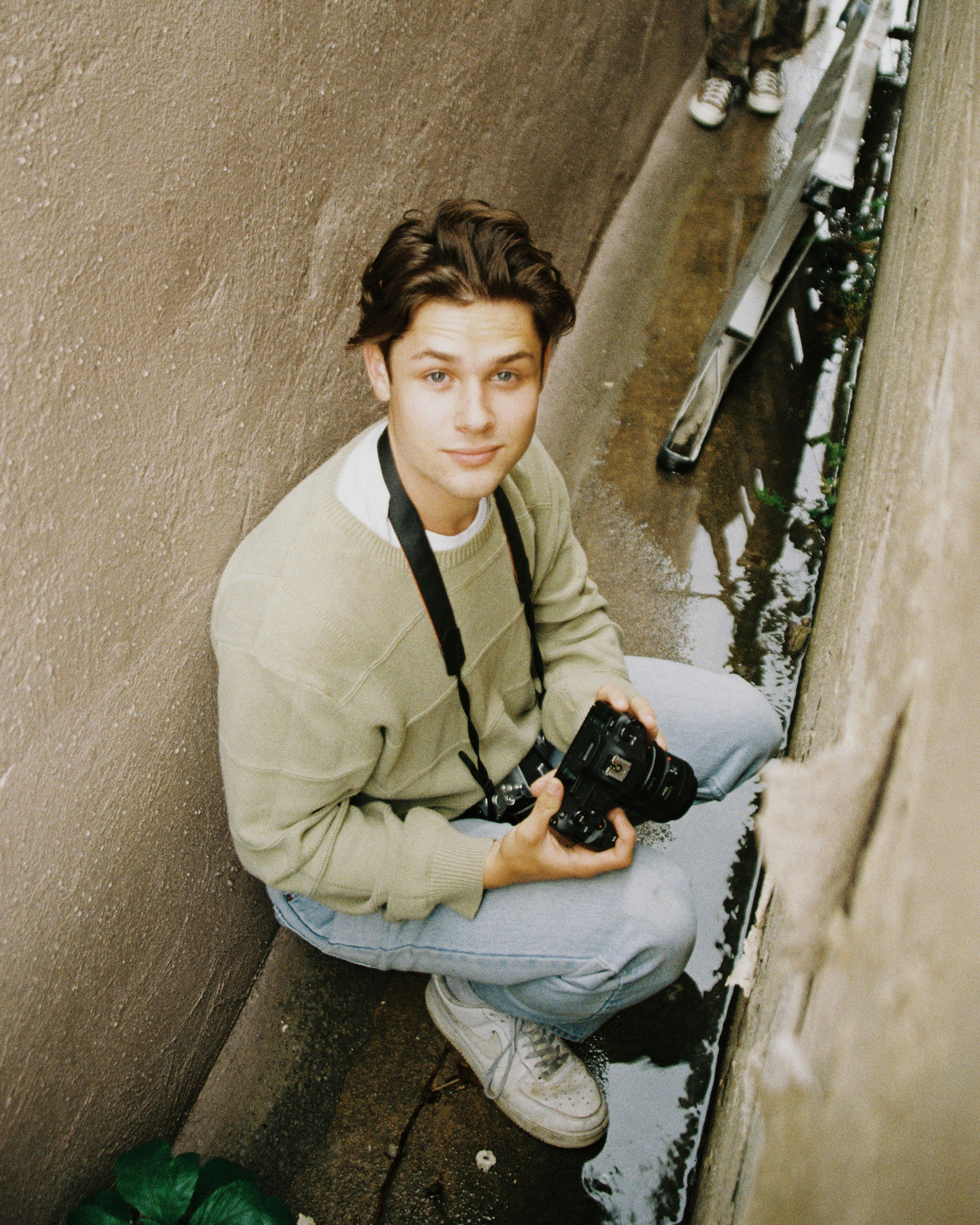 man in white dress shirt holding black dslr camera