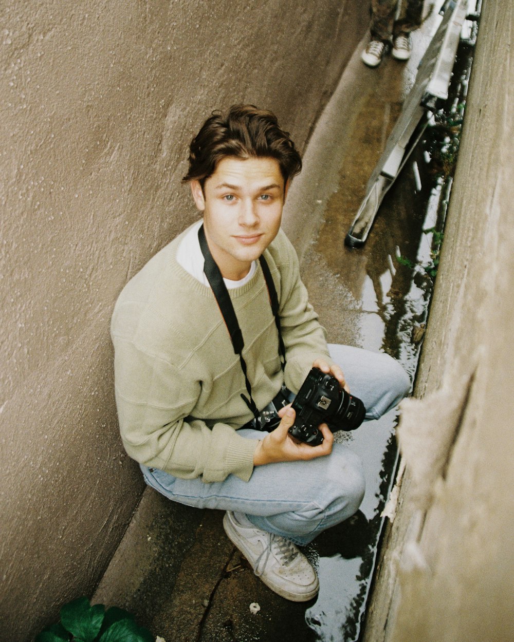 man in white dress shirt holding black dslr camera