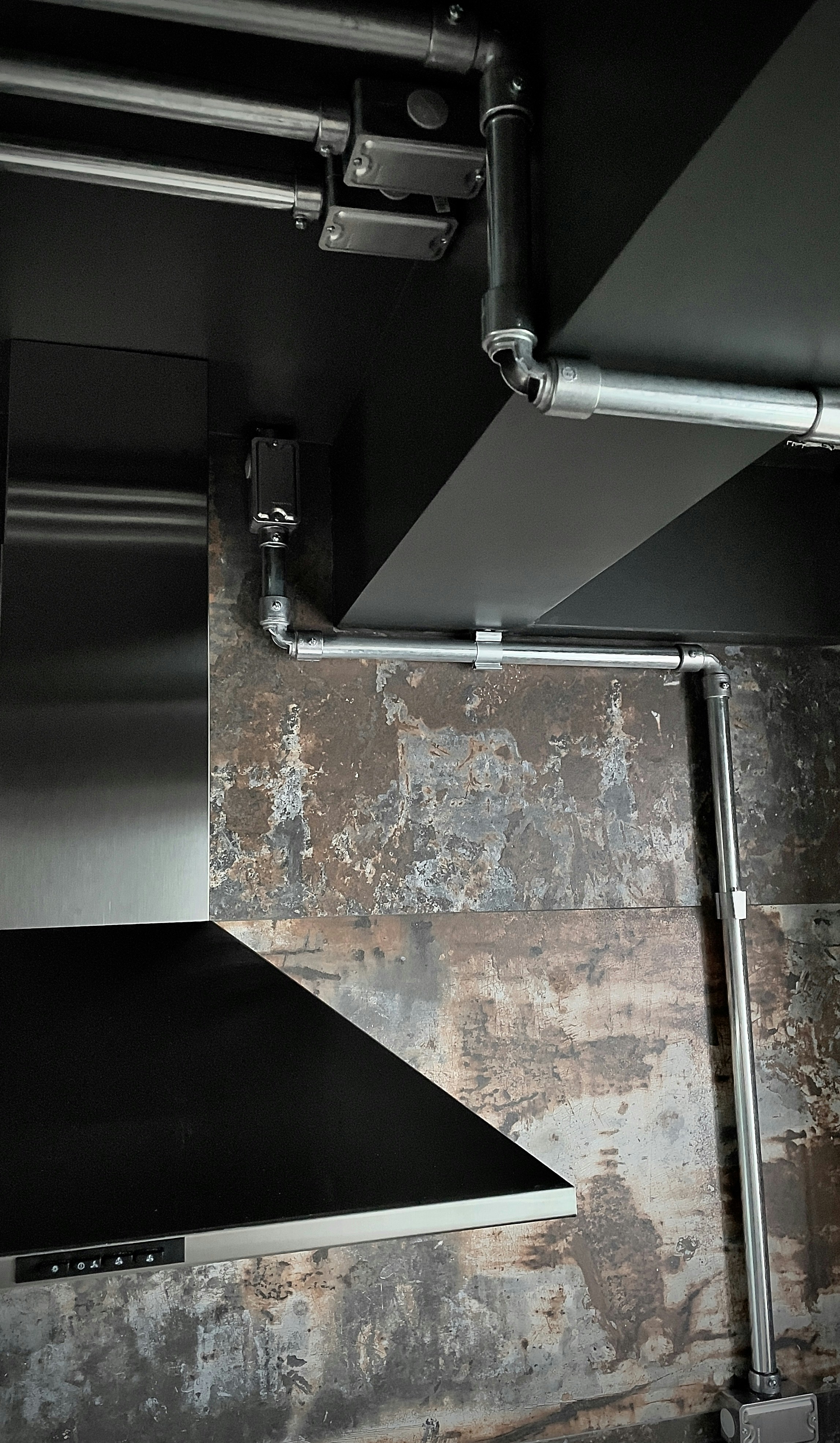 Modern stainless steel ventilation hood installed above a commercial cooking area.