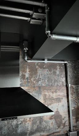 Industrial kitchen exhaust system with visible ductwork and ventilation fans.