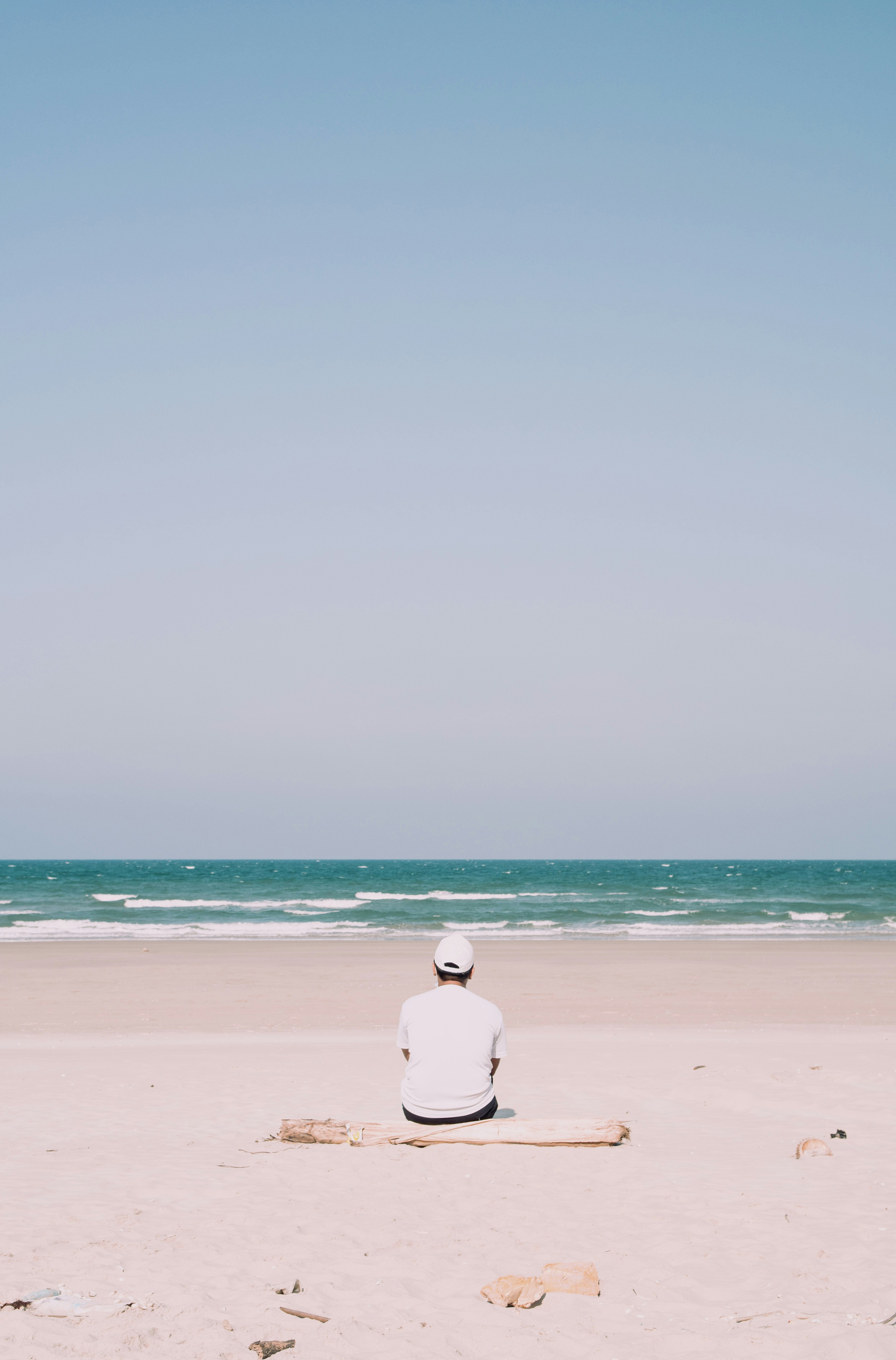 a person sitting on a log on a beach