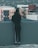 woman in black long sleeve shirt and black pants standing on gray concrete wall during daytime