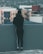 woman in black long sleeve shirt and black pants standing on gray concrete wall during daytime