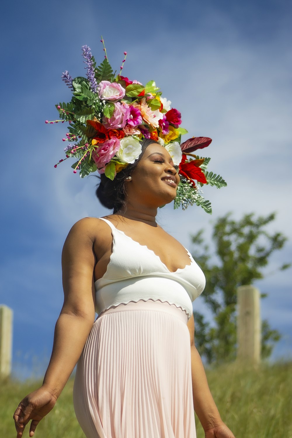 woman in white spaghetti strap dress with flower on head