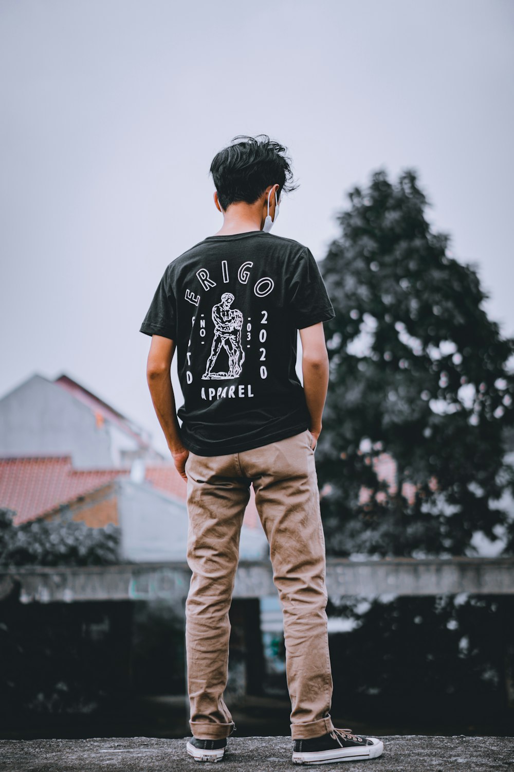 man in black crew neck t-shirt and brown pants standing