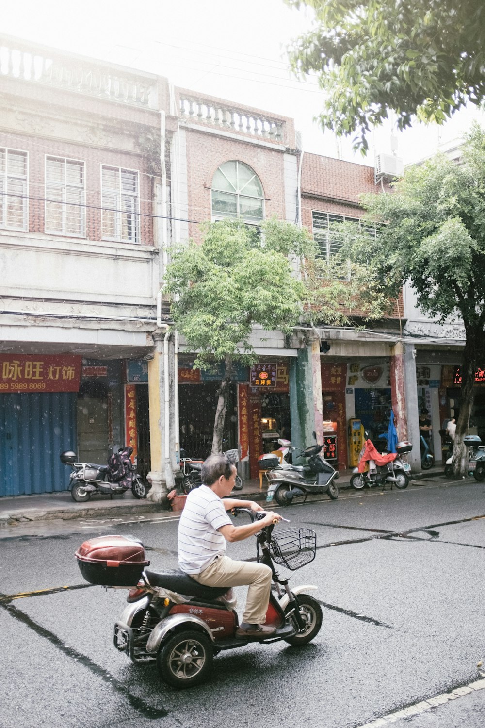 man in white t-shirt riding bicycle on road during daytime