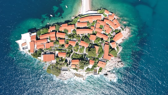 aerial view of houses near body of water during daytime in Sveti Stefan Montenegro