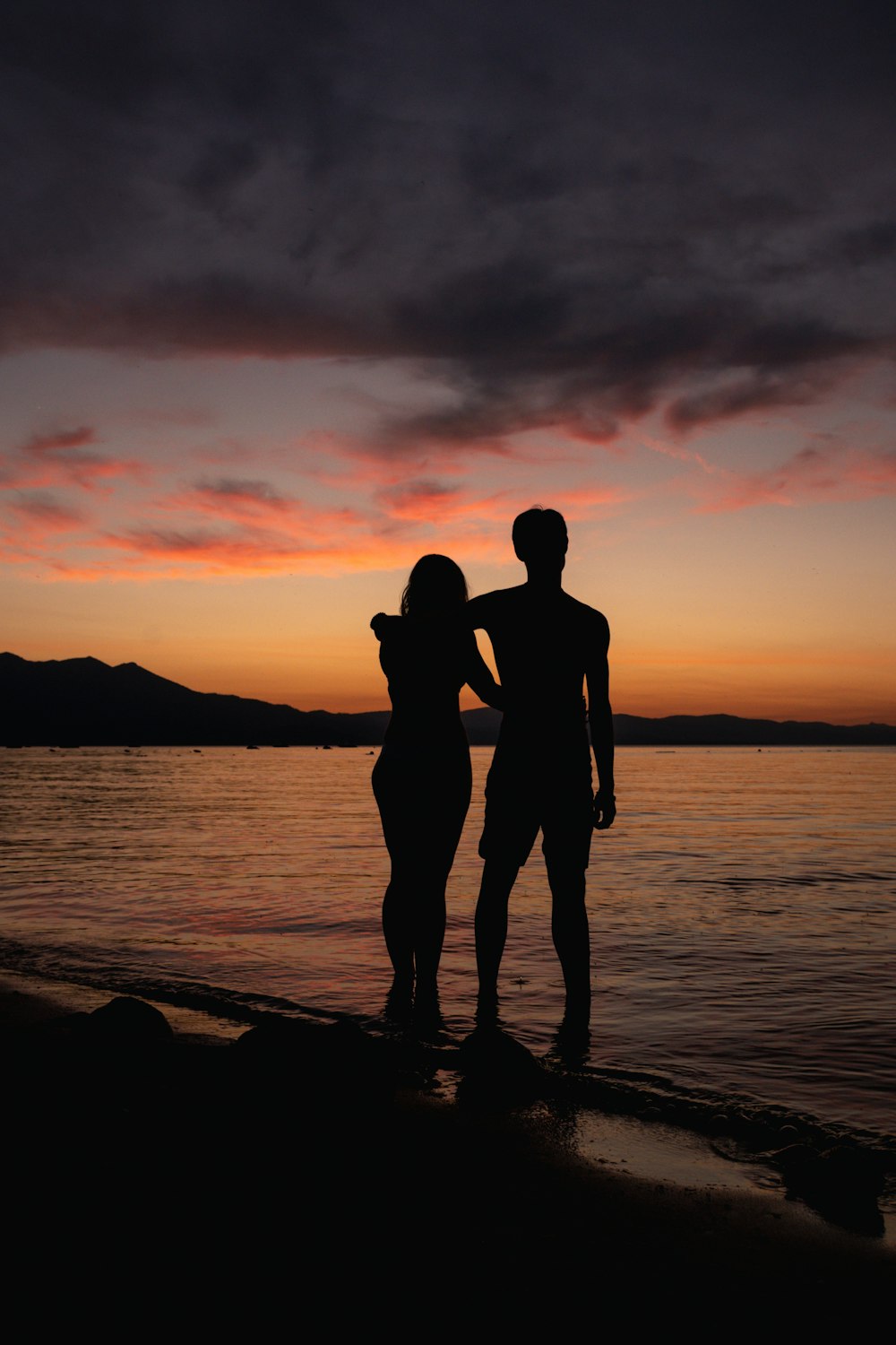 silhouette of couple kissing on beach during sunset