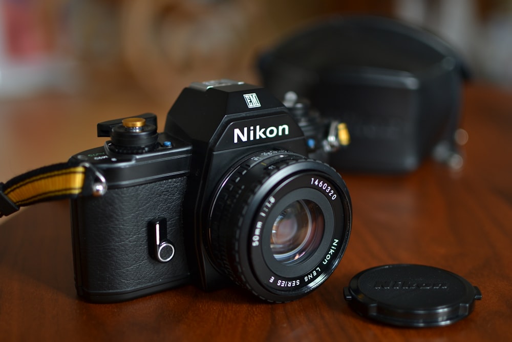 black nikon dslr camera on brown wooden table