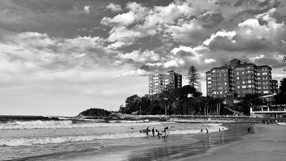 Photo en niveaux de gris de personnes sur la plage