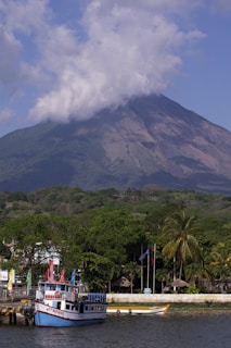 people walking on street near green mountain under white clouds during daytime