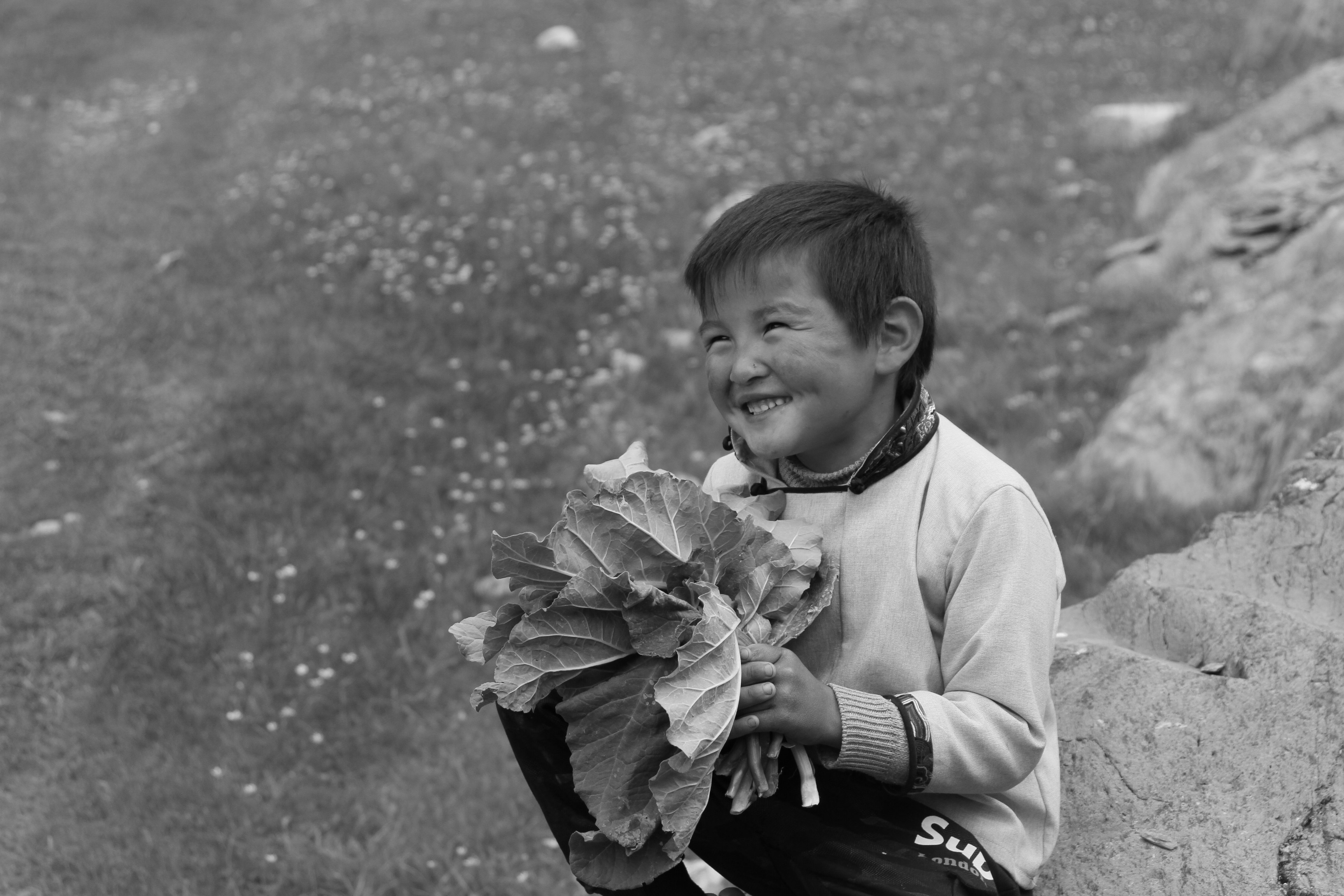 grayscale photo of girl in white long sleeve shirt holding white flower