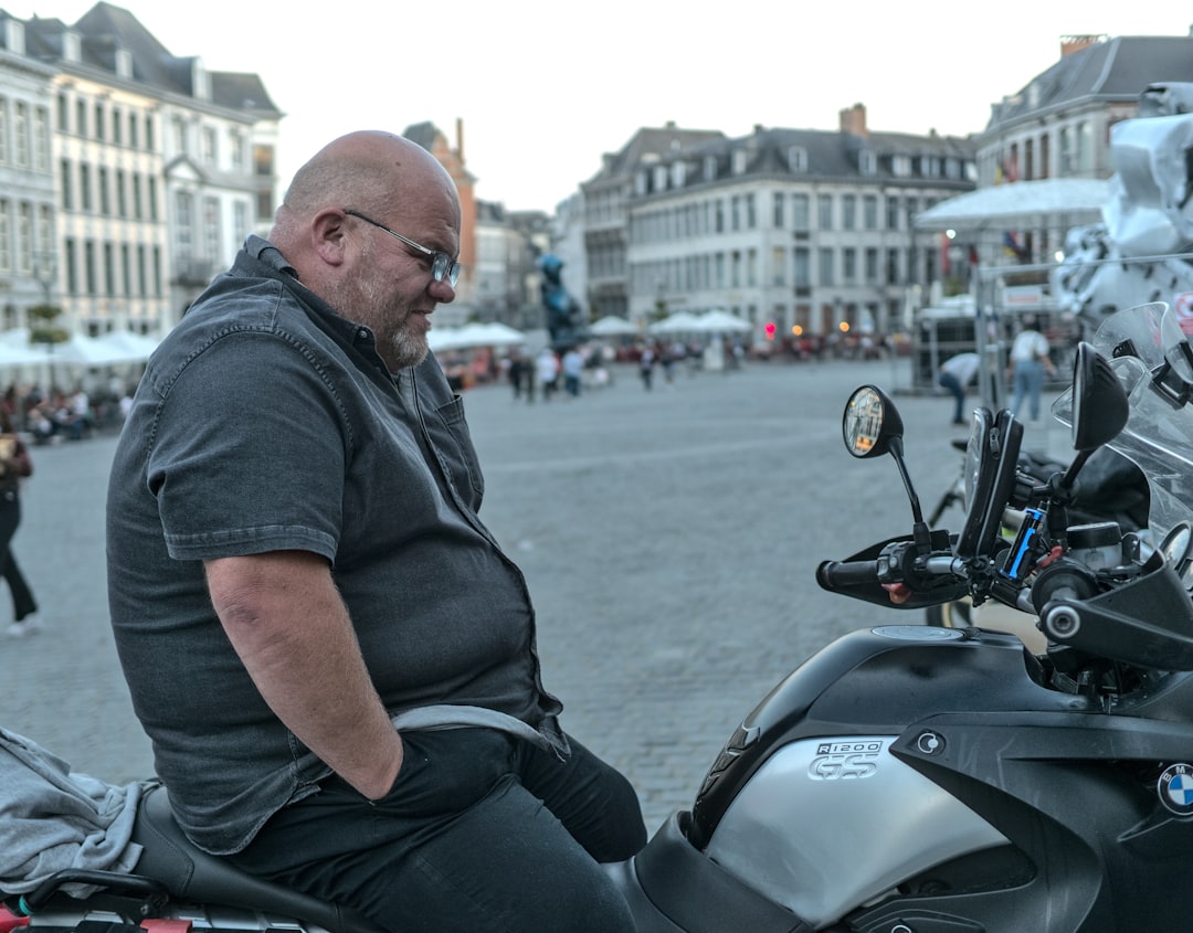 man in black button up shirt and black pants sitting on motorcycle