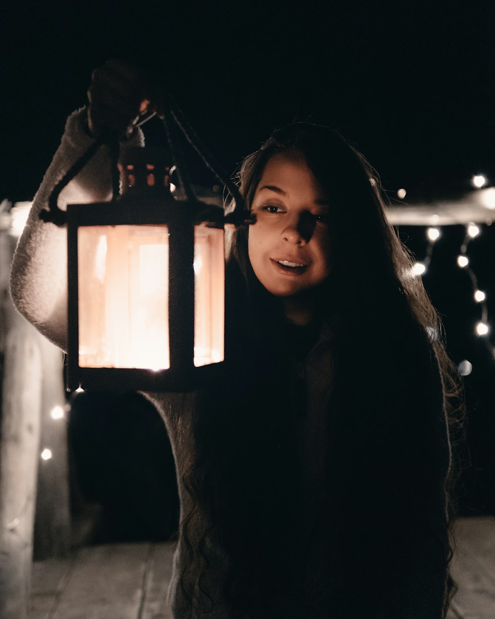 woman in black long sleeve shirt holding lantern