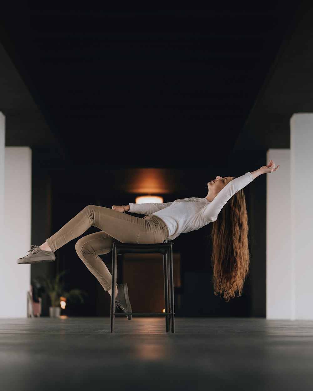 woman in white long sleeve shirt and gray pants sitting on chair