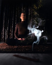 topless man sitting on bench with fire in front