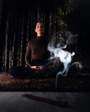 topless man sitting on bench with fire in front