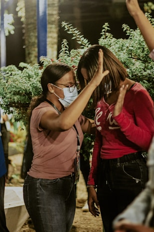 woman in red shirt covering her face with her hair