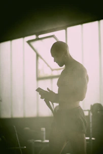 Athlete training intensely with AI-powered coaching app on smartphone in a modern gym.