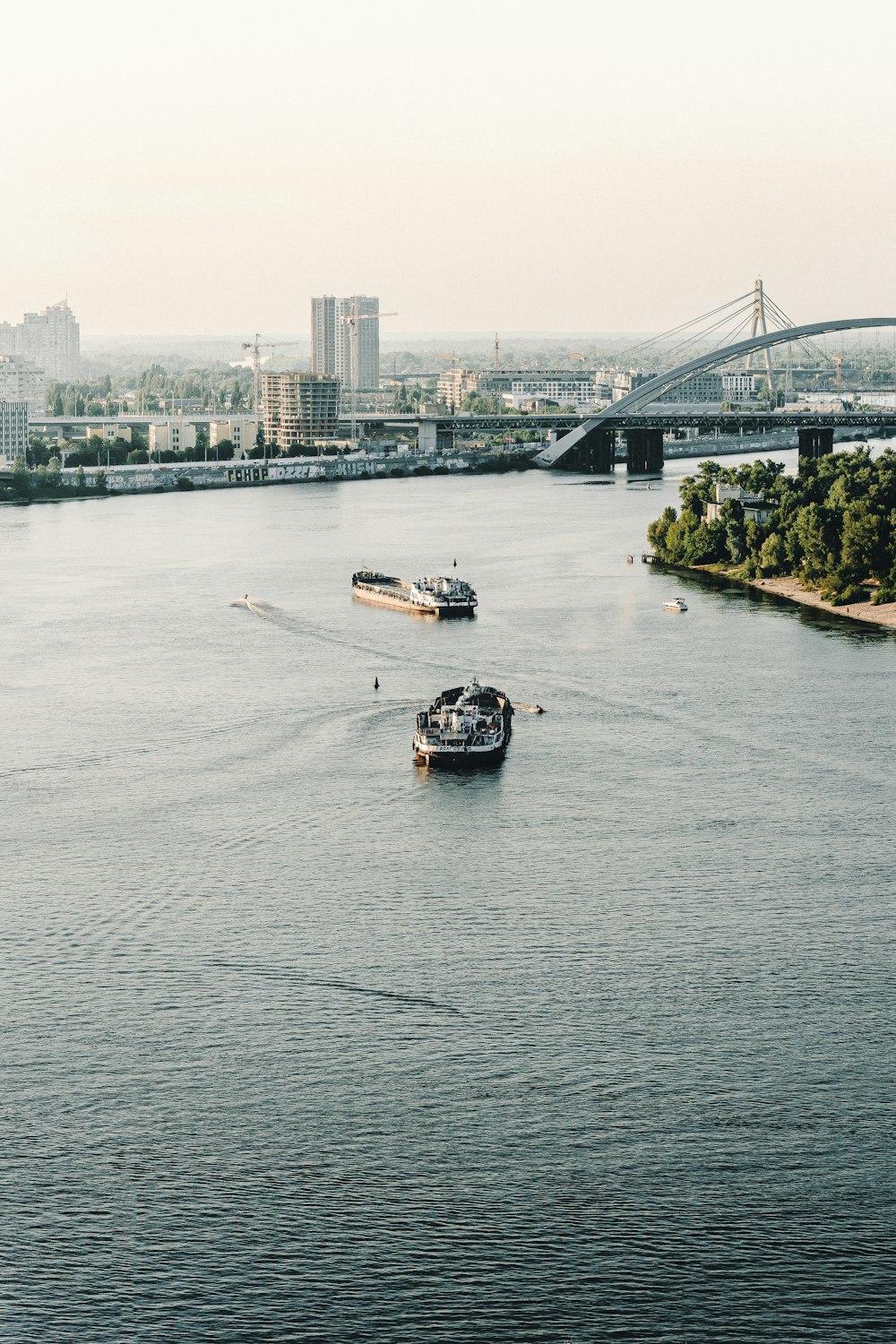 white and black boat on water near bridge during daytime