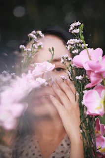 woman in black shirt holding pink rose