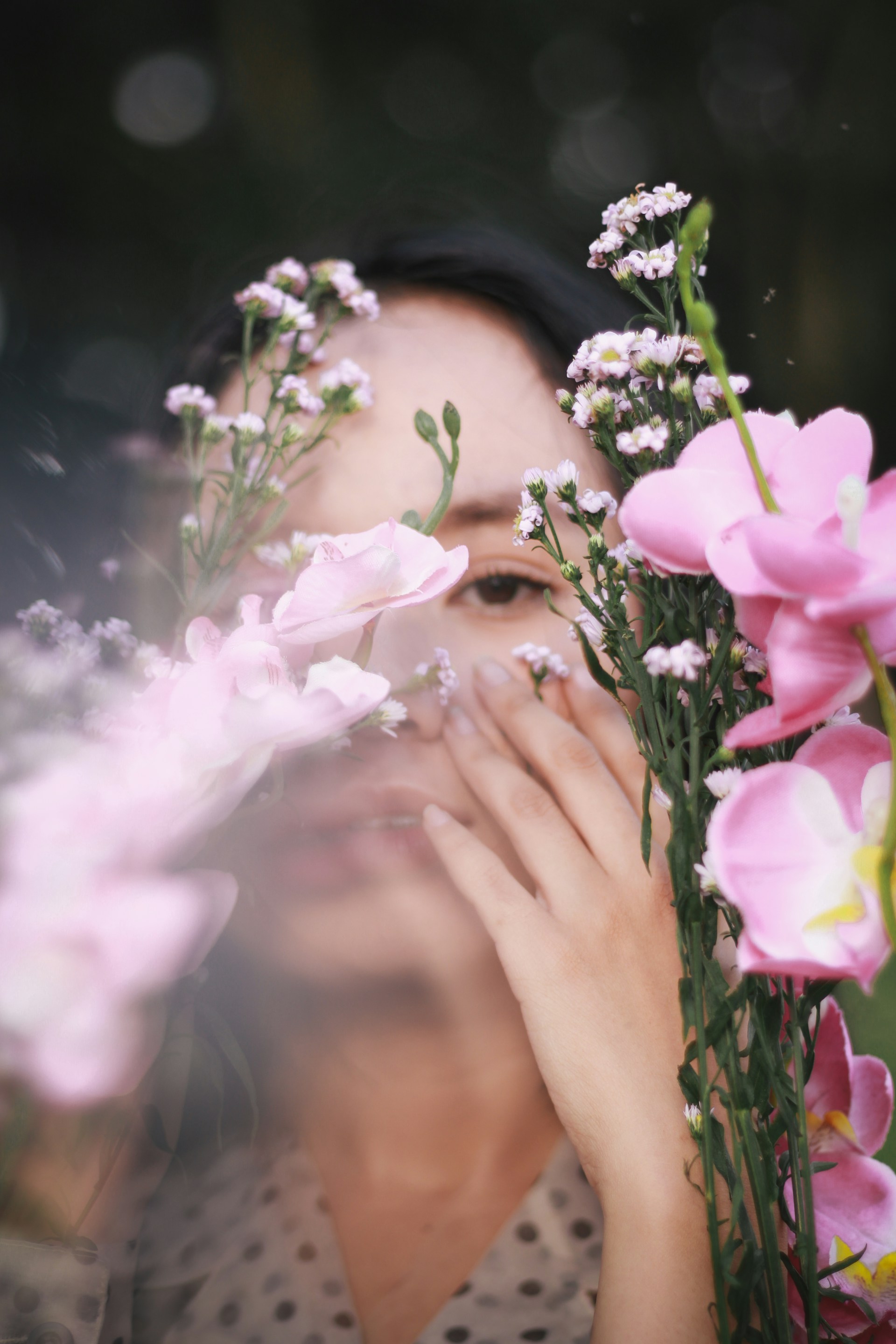 woman in black shirt holding pink rose