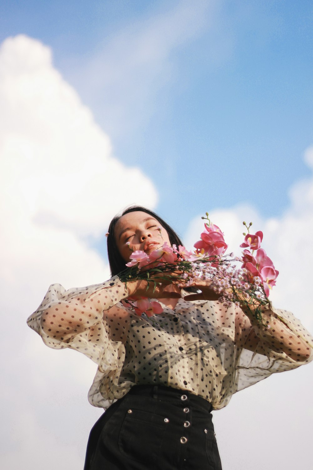 woman in white and black floral dress under white clouds during daytime