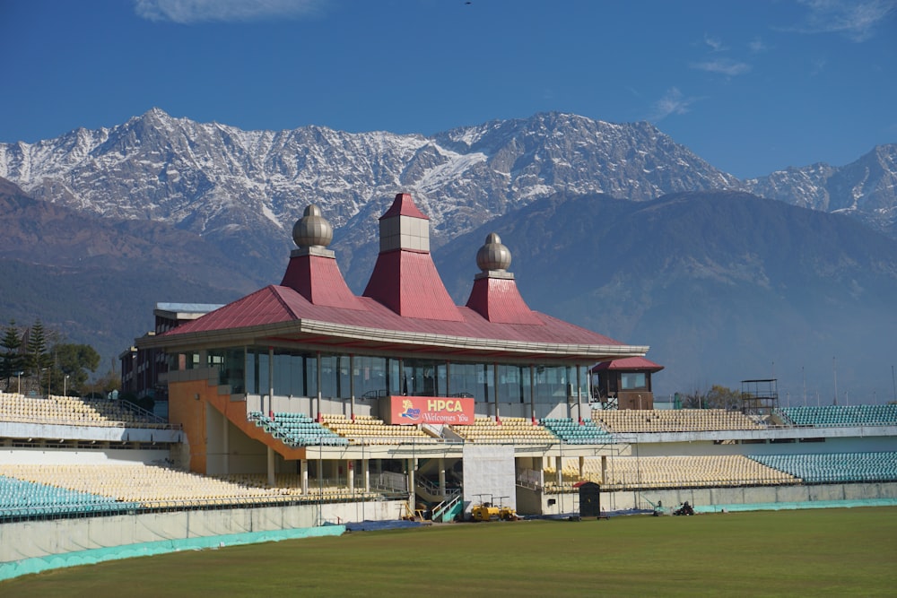 red and white concrete building near snow covered mountain during daytime