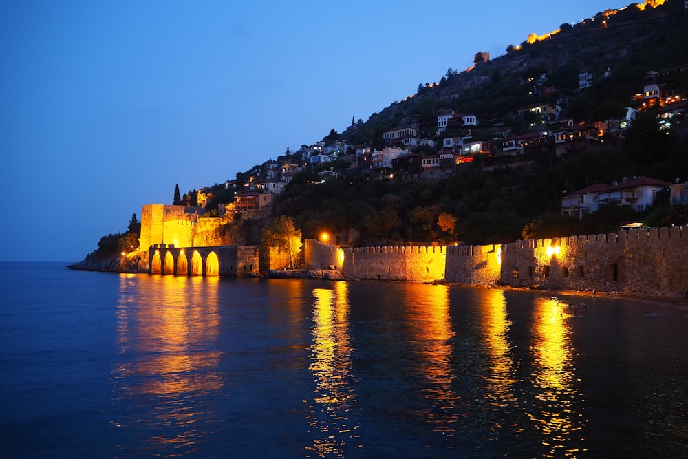 brown concrete building near body of water during night time