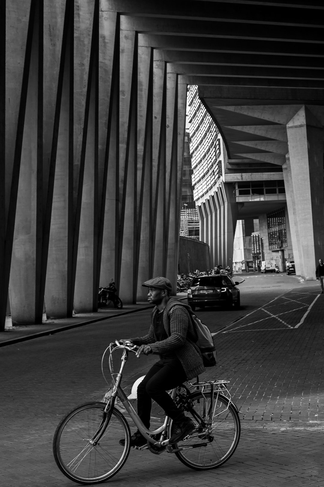 grayscale photo of man riding bicycle