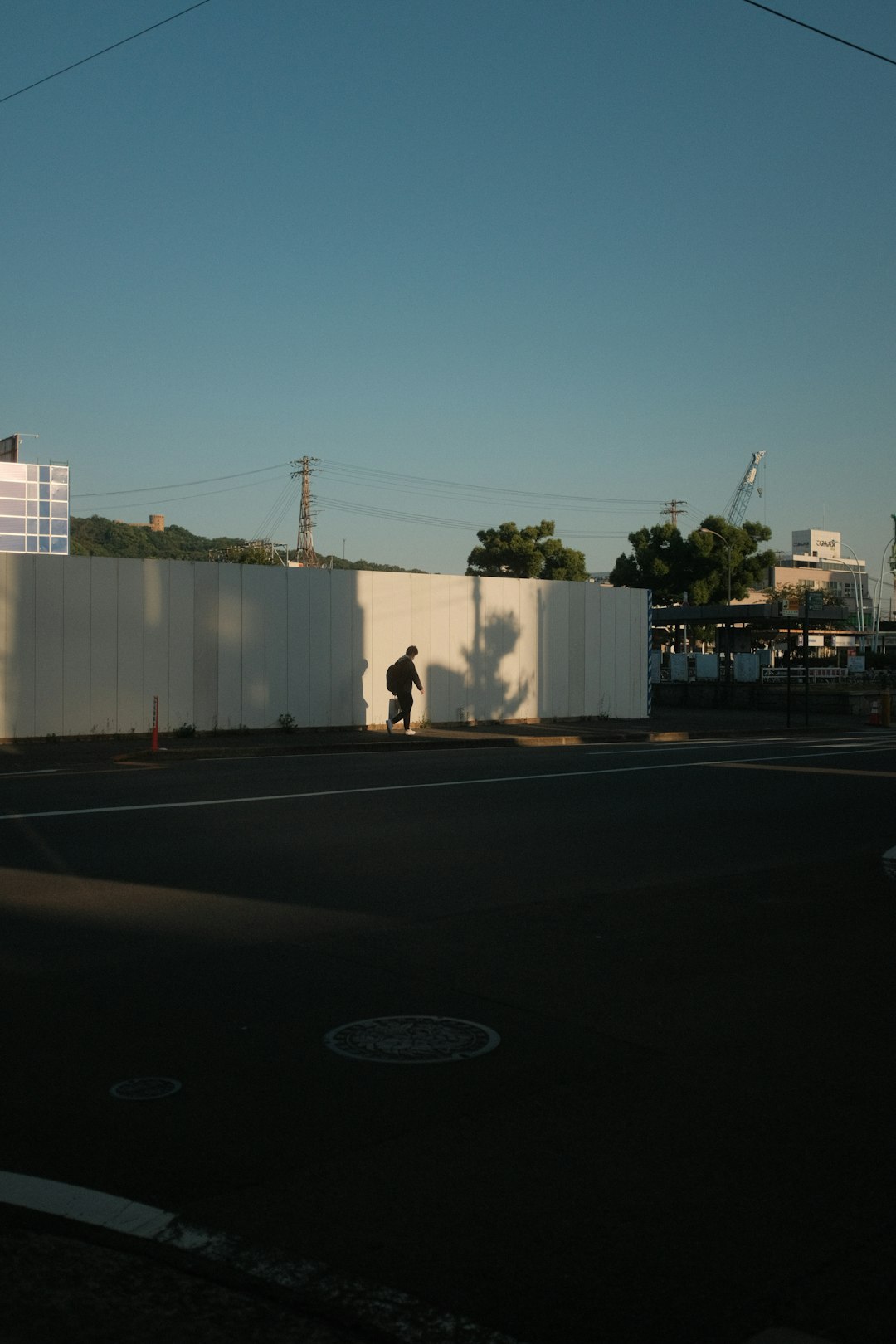 man in black shirt and pants walking on sidewalk during daytime