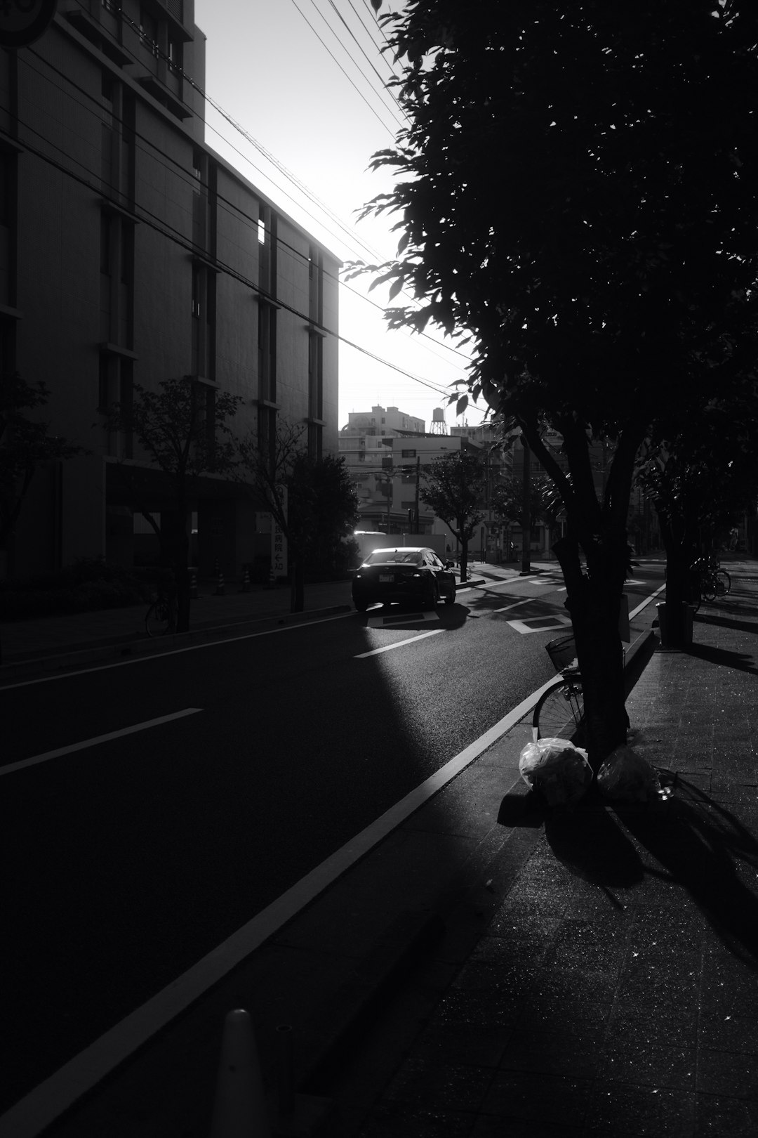 grayscale photo of cars parked on side of the road