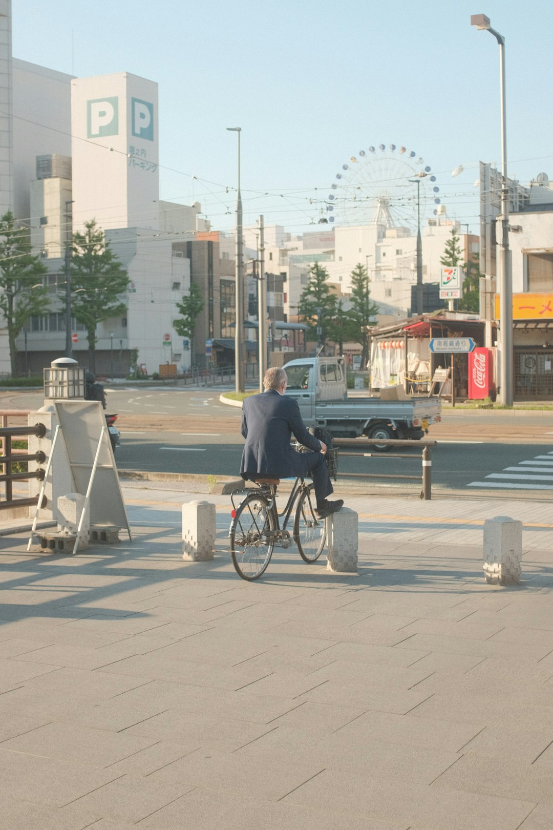 man in blue jacket sitting on black wheelchair on gray concrete road during daytime