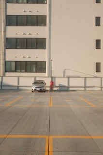 white car on road near white building during daytime