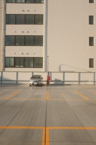 white car on road near white building during daytime