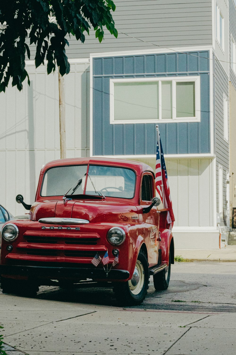 red vintage car parked beside white building