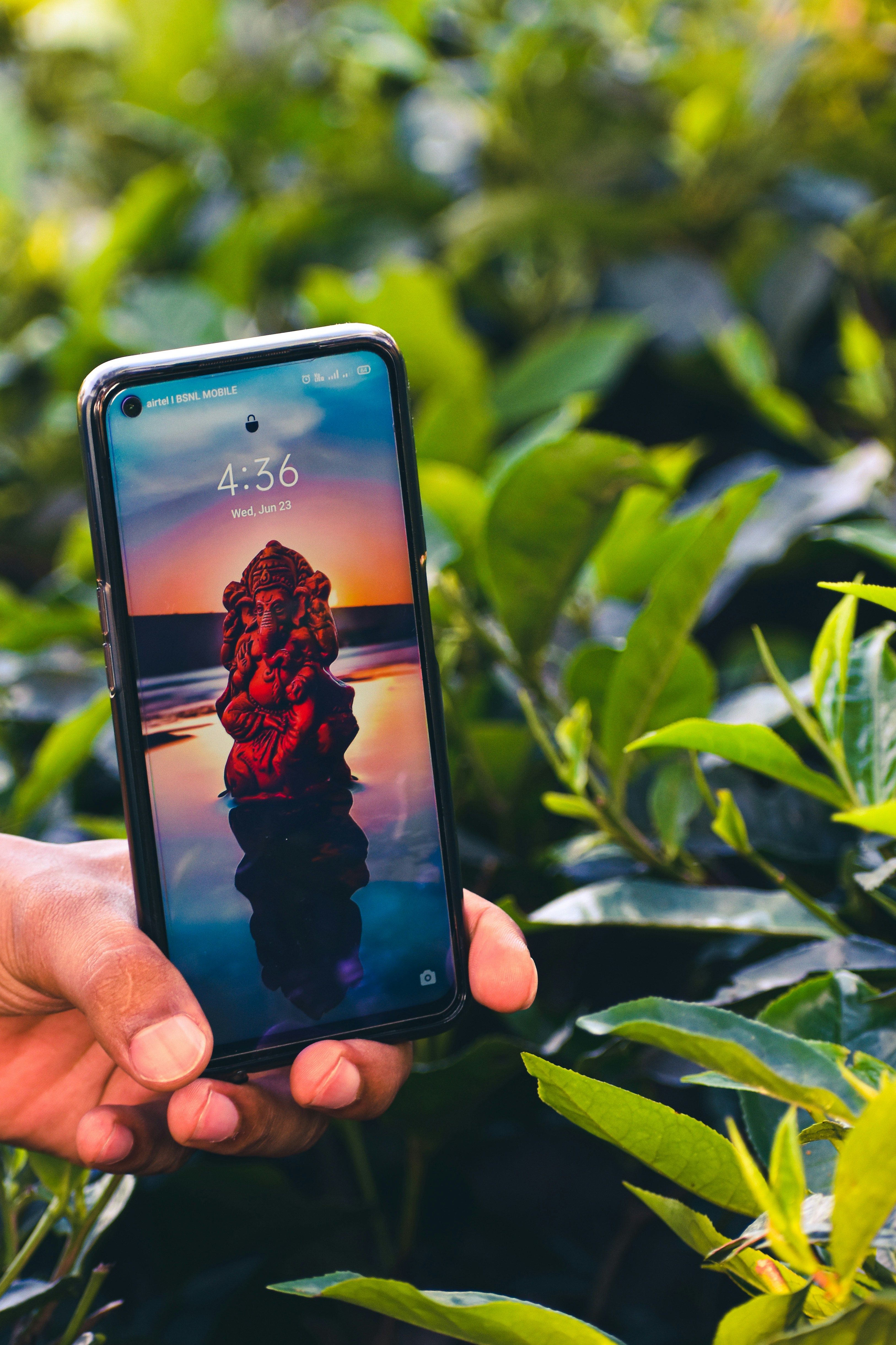 Person mit schwarzem iPhone 5 mit grüner Hülle