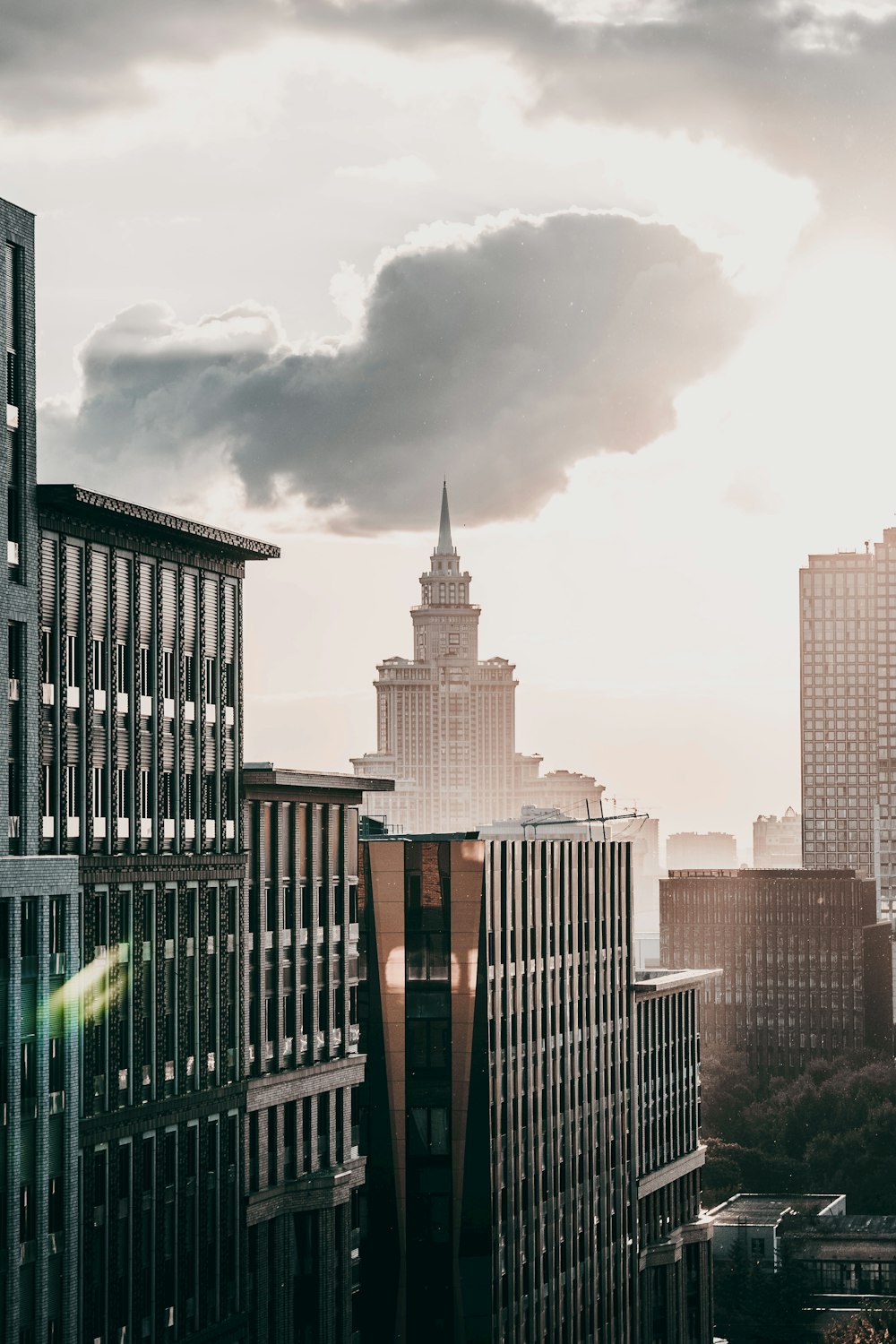 brown and black concrete buildings under white clouds during daytime