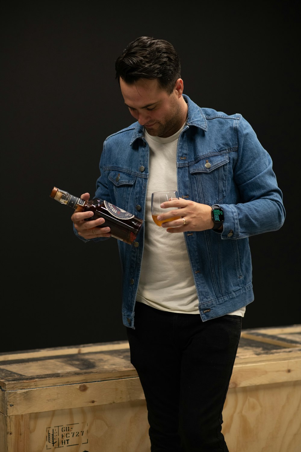 Mann in blauer Jeansjacke mit Smartphone